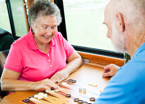 Senior couple in the kitchen of their motor home playing backgammon.