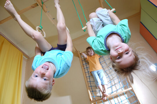 three 5 year old children playing with home sport gym