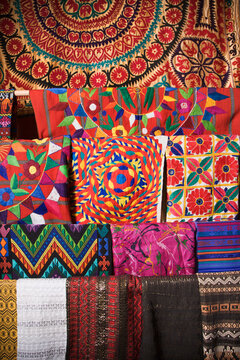 Colorful Mexican patterned fabric hanging on a rack. Vertical shot.