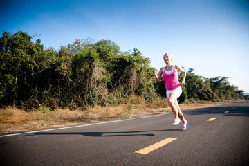 Blond young woman running cross country. Subject is blurred due to motion.