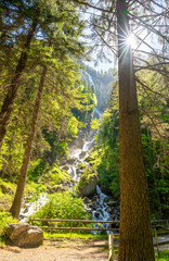 waterfall in Alps with sunbeam in Switzerland