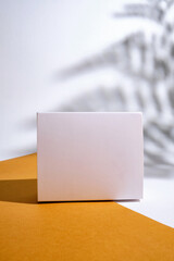 Small box on a light background. Empty packaging, empty space. Postal services, delivery. White paper. Gift box, gift. Box close-up. Сardboard box