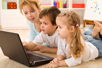 Family online - kids learning the use of computers with their mother