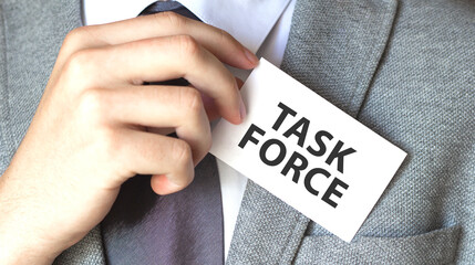 Businessman putting a card with text TASK FORCE in the pocket