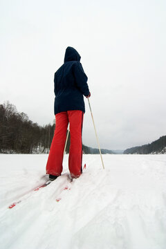 A cross country skier out on a refreshing trip over a frozen lake.