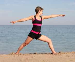 Woman doing yoga exercise on the beach