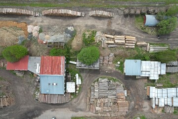 Aerial view of stacked logs near a railway yard, showcasing industrial timber storage and its role...