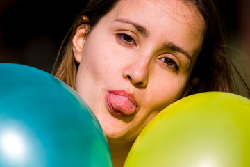 Cute girl between two colored balloons