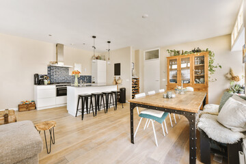 a kitchen and living room in an apartment with wood floors, white walls, hardwood flooring and large windows