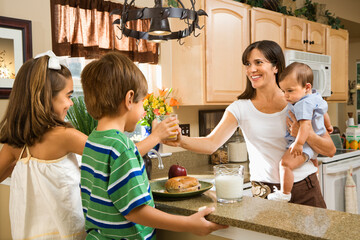 Hispanic family in kitchen with breakfast.