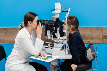 Pediatric ophthalmologist with slit lamp examines eyes and cornea of child. Ophthalmologist...
