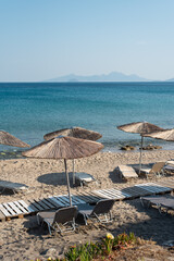 beach with umbrellas and chairs greece Mediterranean sand sea ocean resort vacation relax travel...