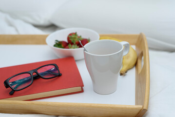 Healthy breakfast of coffee, strawberry, banana and a book