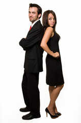 Full body of attractive young brunette man and woman man in black business suit and woman in black dress standing back to back over white