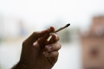 Hand holding a marijuana cigarette
