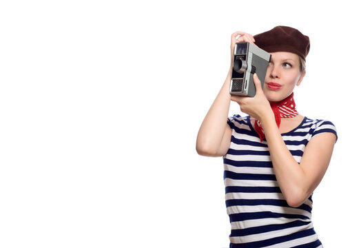 beautiful girl with red bandana, beret and striped shirt in a classic 60s french look holding a vintage 8mm substandard camera