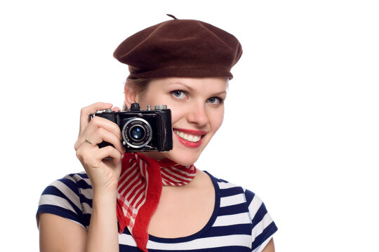 beautiful girl with red bandana, beret and striped shirt in a classic 60s french look holding an old photo camera