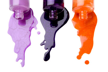 The color nail polish which is pouring out from bottles on a white background
