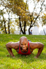 An african american doing push ups in the park