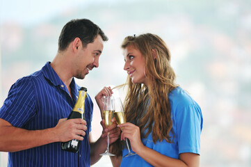 happy couple at big bright comfort apartment celebrate with glasses of champagne