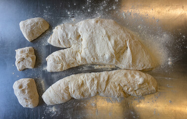 Cutting Ciabatta dough on a metal table using a bench scrape Top view