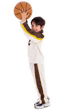 young caucasian boy while playing basket ball over white background
