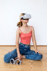 A portrait of a girl in vr glasses with controllers in hands