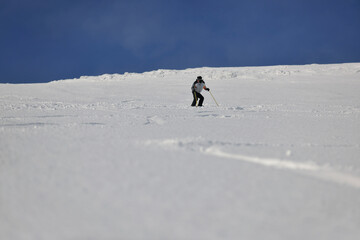 skier free ride downhill at winter season on beautiful sunny day