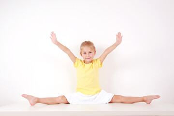 Fototapeta na wymiar Cute little girl making splits on white background