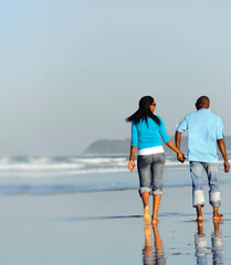 Happy couple walking on the beach in summer