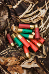 Still life shot of shotgun shells against camouflage clothing.