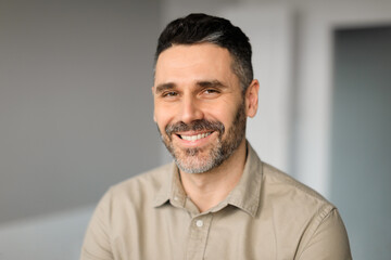 Fototapeta premium Portrait of happy middle aged businessman working in office, posing and smiling at camera, copy space