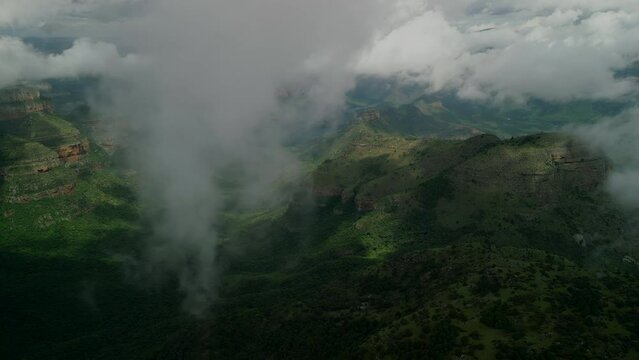 Flying in clouds with canyon on background 
