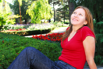 Obraz premium Mature woman relaxing outside in summer park