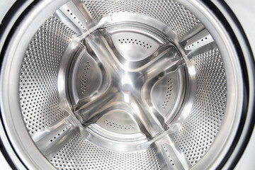 Inside of washing machine. Rotating inner tub. Material metal. Close-up of electrical household appliance.