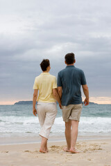 Couple walking hand in hand on the beach