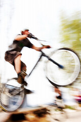 Fototapeta na wymiar Boy on a bmx/mountain bike jumping. Motion blur photo f/x