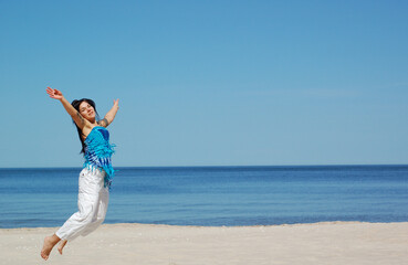 Obraz premium attractive woman jumping on the beach