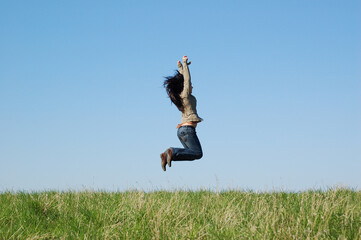 happy woman jumping on green meadow