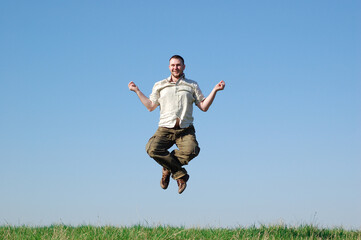 Obraz premium happy man jumping on green meadow