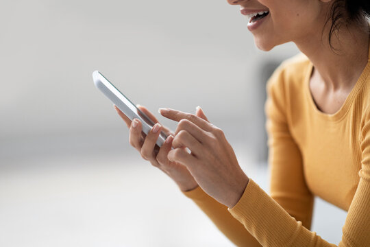 Smiling Young Woman Using Modern Smartphone At Home, Side View
