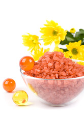 Fototapeta na wymiar spa pruducts: bath salt, oil balls in a bowl and yellow flowers