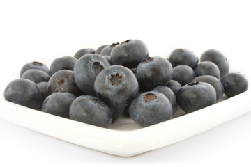 A plate with fresh blueberries isolated on white background, with shadow.