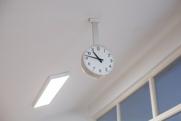 large analog clock hanging from ceiling