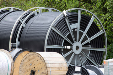 big rolls of black power cable on construction site