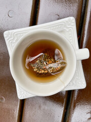 White porcelain cup and saucer resting on varnished noble wood