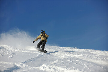 Fototapeta na wymiar freestyle snowboarder jump and ride free style at sunny winter day on mountain