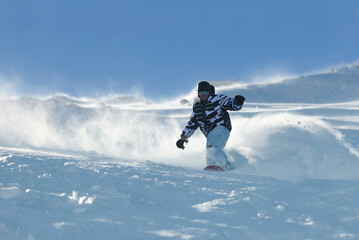 Fototapeta na wymiar freestyle snowboarder jump and ride free style at sunny winter day on mountain