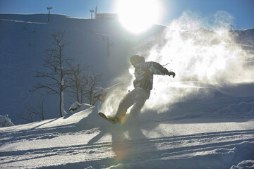 freestyle snowboarder jump and ride free style  at sunny winter day on mountain
