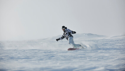 freestyle snowboarder jump and ride free style  at sunny winter day on mountain